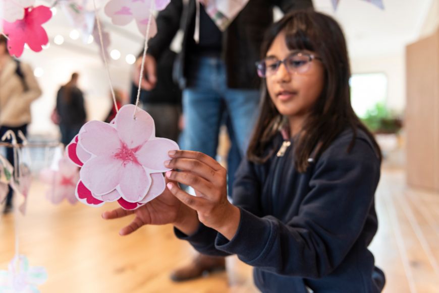 a child hanging a blossom image